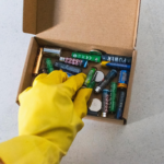 persona depositando una pila en una caja para posteriormente llevar a un punto de recogida especial